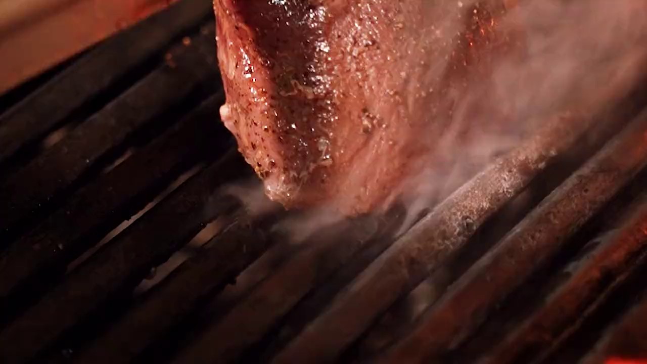 A steak searing over an open flame grill
